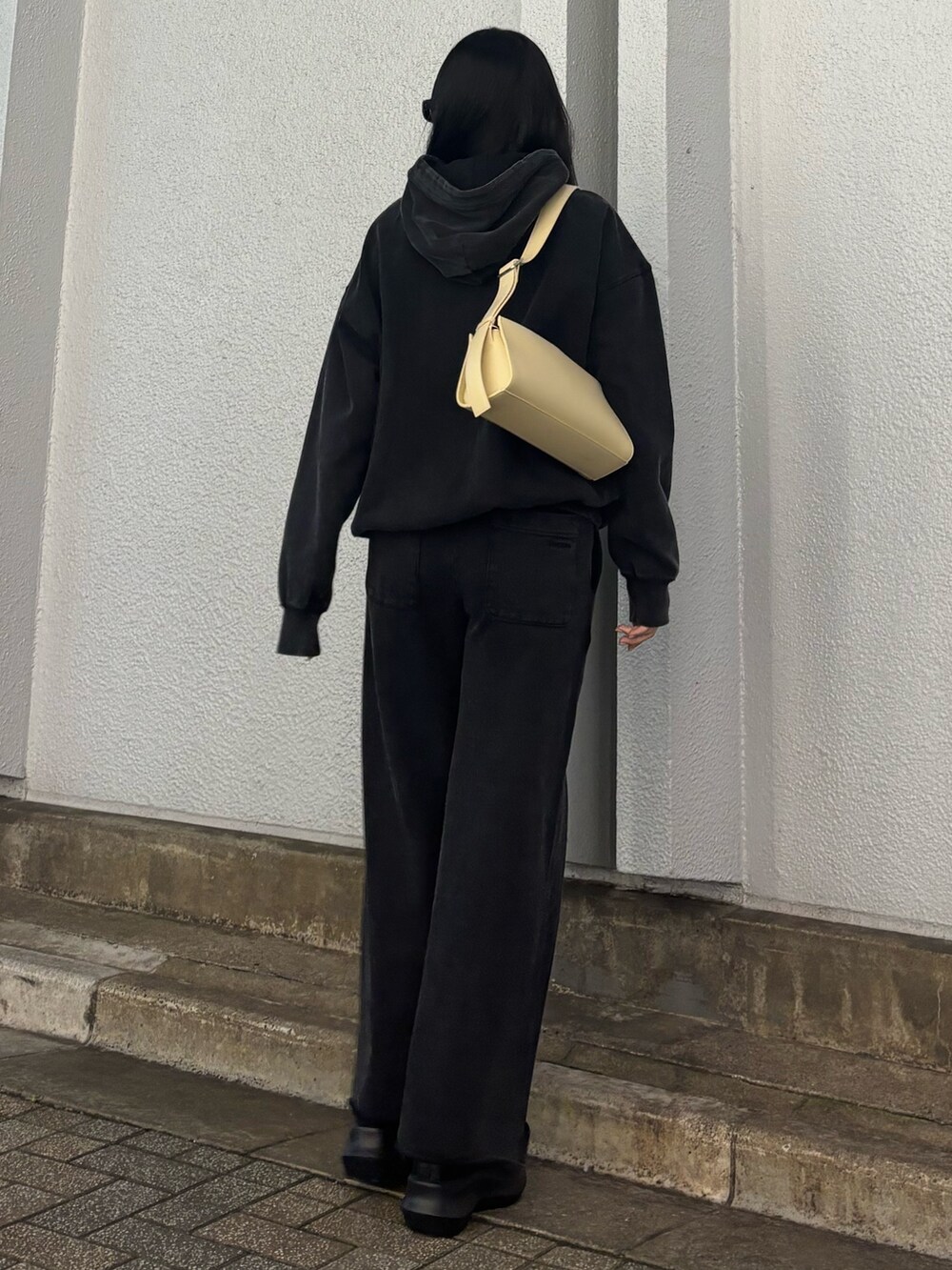 ベージュ系のハンドバッグ、ブラック系のスウェット、ブラック系のスウェットパンツを着用したレディースの秋コーディネートの3枚目の写真