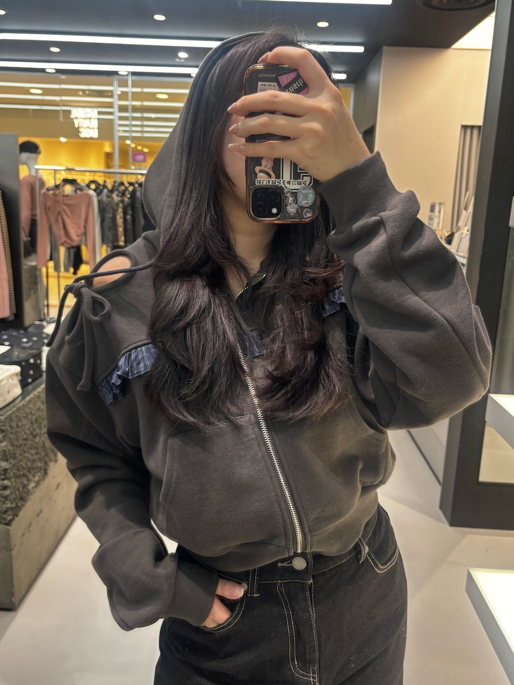 ブラック系のブーツ、ブラック系のパーカー、ブルー系のスカートを着用したレディースの冬コーディネートの3枚目の写真