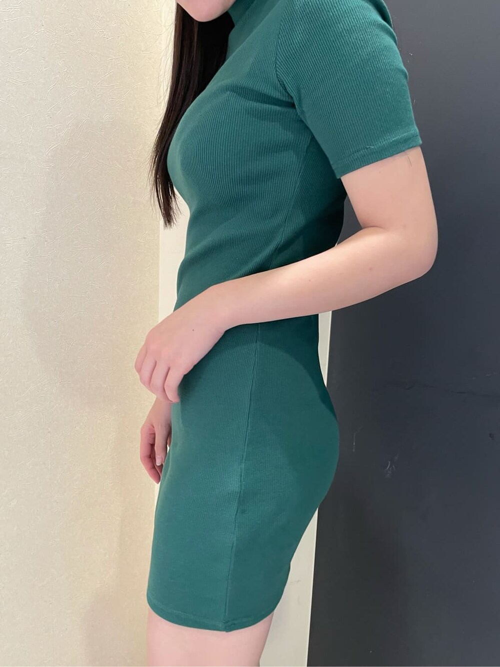 グリーン系のワンピース、ブラック系のハットを着用したレディースの夏コーディネートの3枚目の写真