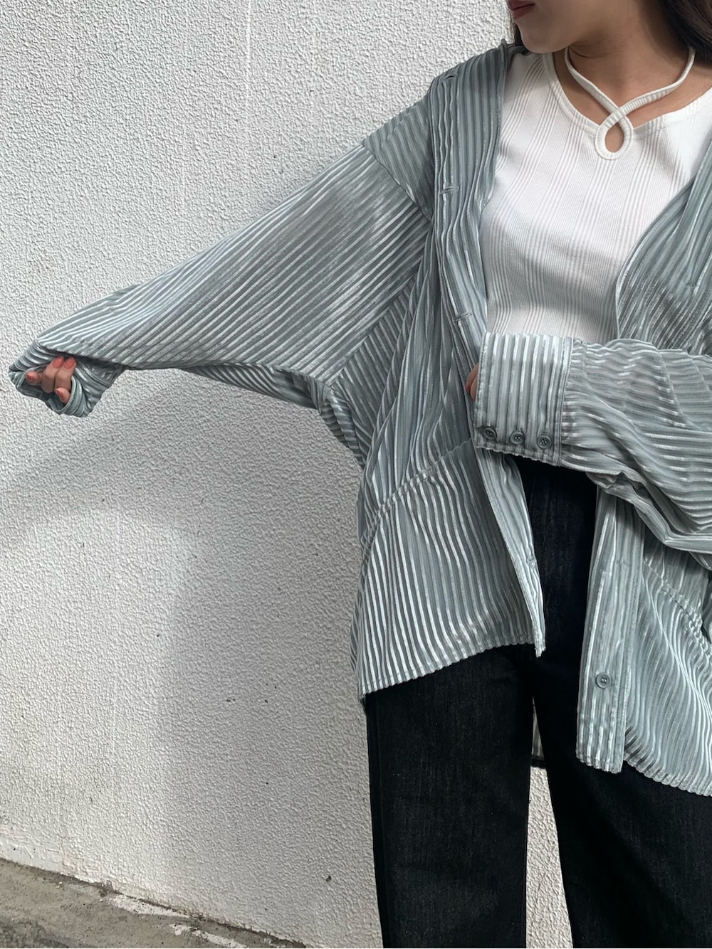 グリーン系のシャツ/ブラウス、ブラック系のサンダル、ブラック系のデニムパンツを着用したレディースの春コーディネートの2枚目の写真