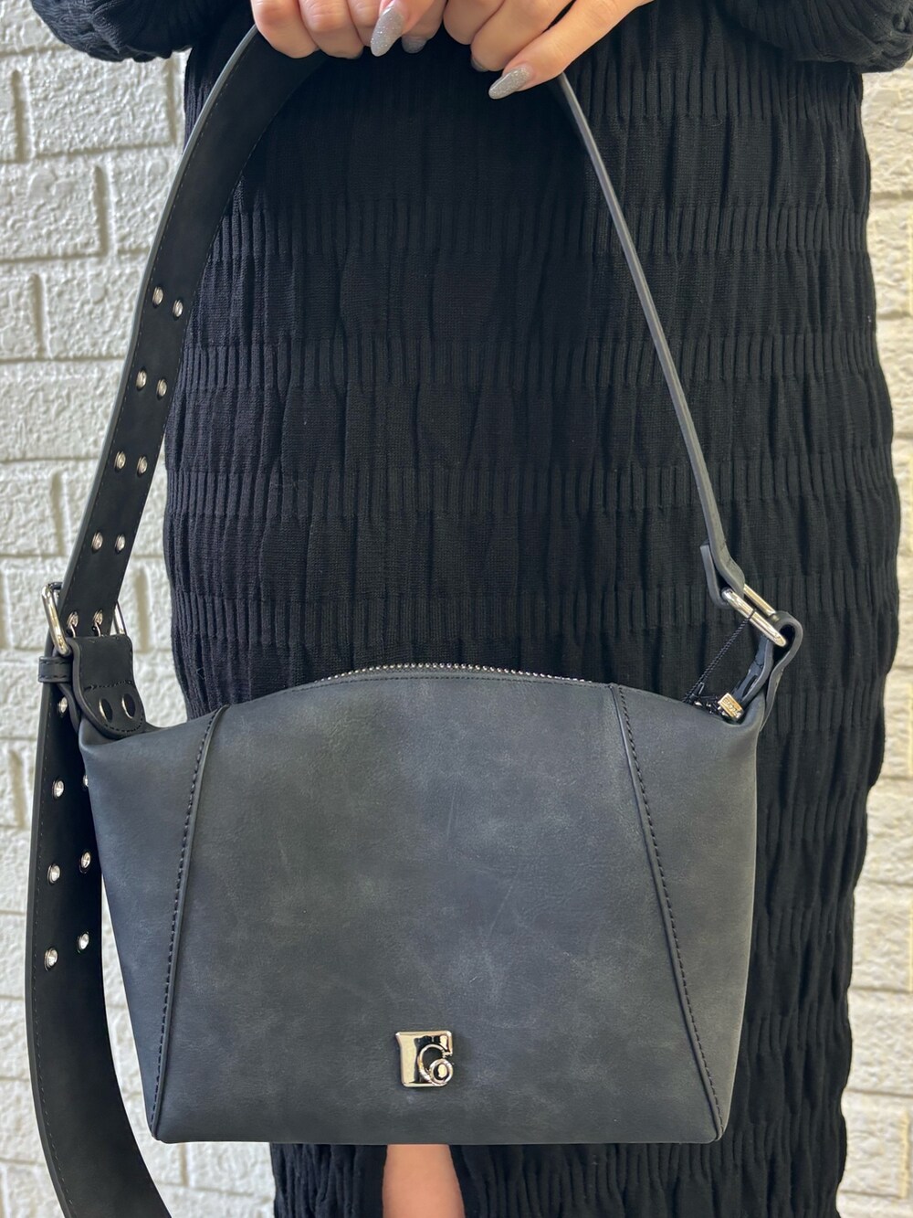 ブラック系のニット/セーター、ブラック系のスカート、ブラック系のショルダーバッグを着用したレディースの冬コーディネートの6枚目の写真