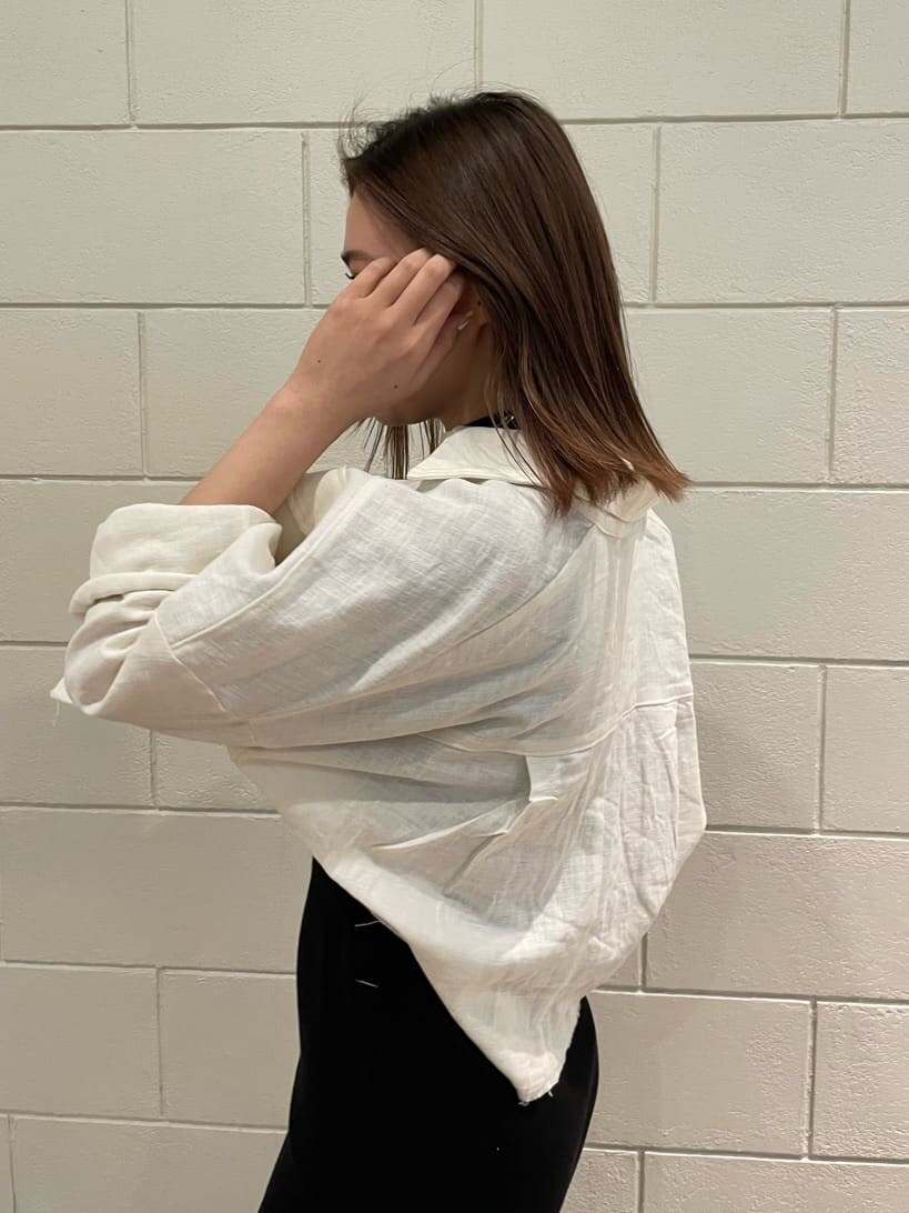 ブラック系のワンピース、ホワイト系のブルゾン、ブラック系のサンダルを着用したレディースの春コーディネートの4枚目の写真