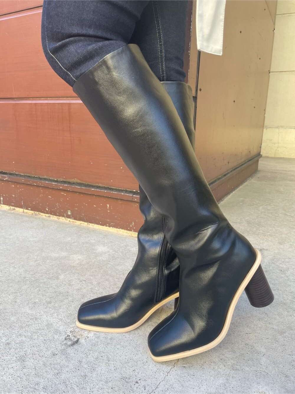 ベージュ系のトレンチコート、ブルー系のデニムパンツ、ブラック系のブーツを着用したレディースの冬コーディネートの7枚目の写真