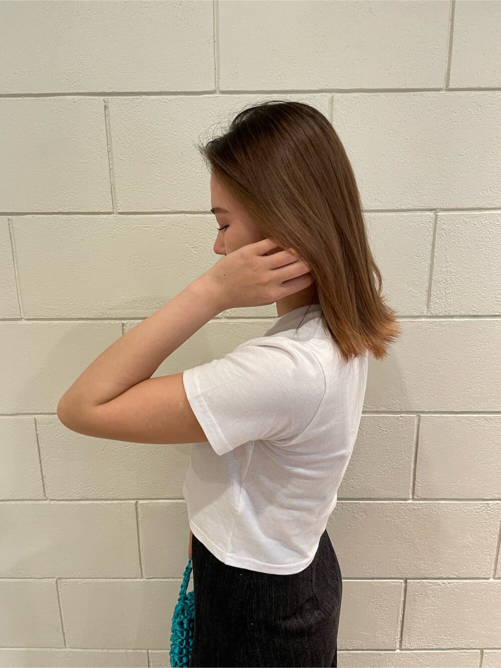 ブラック系のサンダル、ブラック系のスカート、ブルー系のハンドバッグを着用したレディースの春コーディネートの5枚目の写真