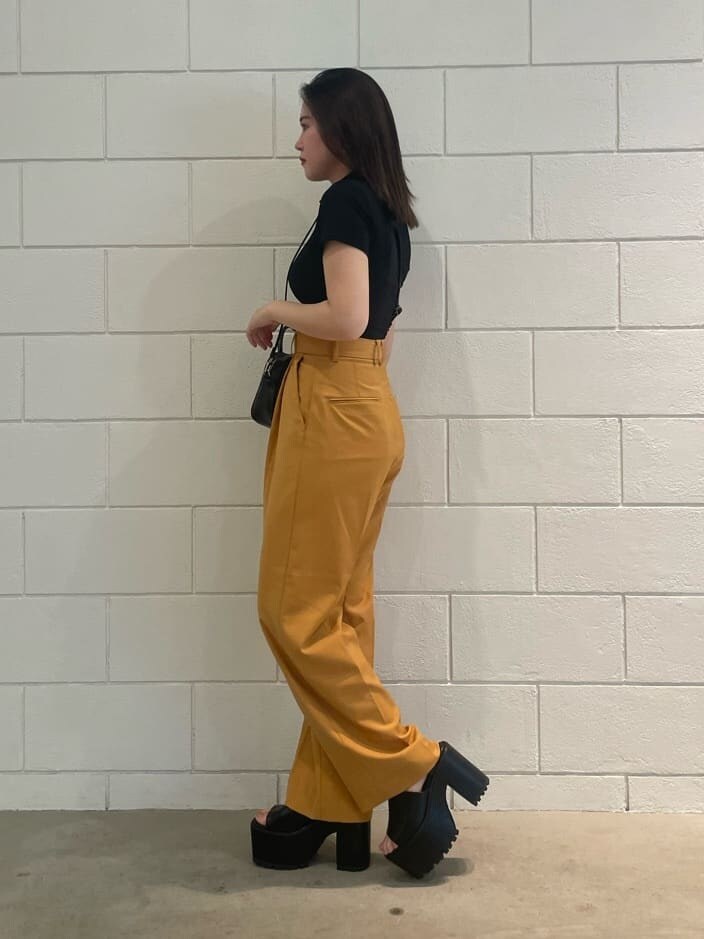 ブラック系のショルダーバッグ、オレンジ系のその他パンツ、ブラック系のサンダルを着用したレディースの夏コーディネートの2枚目の写真