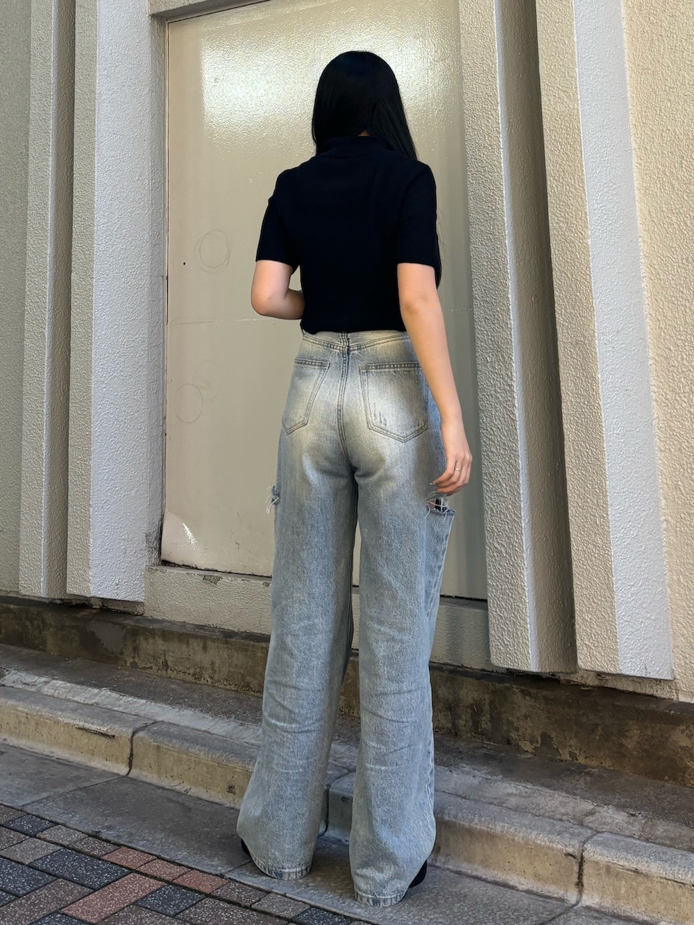 ホワイト系のデニムパンツ、ブラック系のニット/セーター、ブラック系のサンダルを着用したレディースの夏コーディネートの3枚目の写真