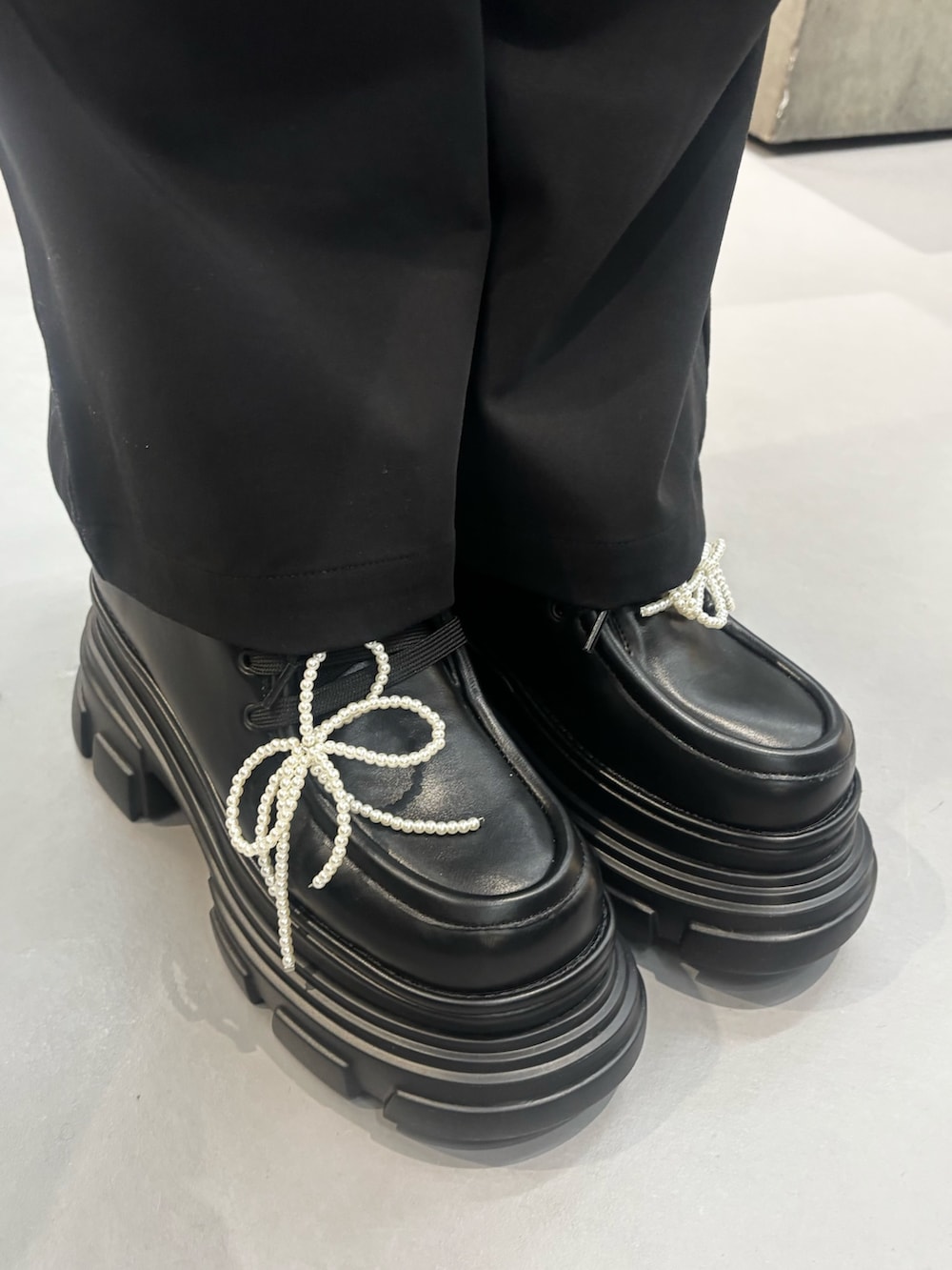 ブラック系のローファー、ブラック系のその他パンツ、ブラック系のハンドバッグを着用したレディースの秋コーディネートの4枚目の写真