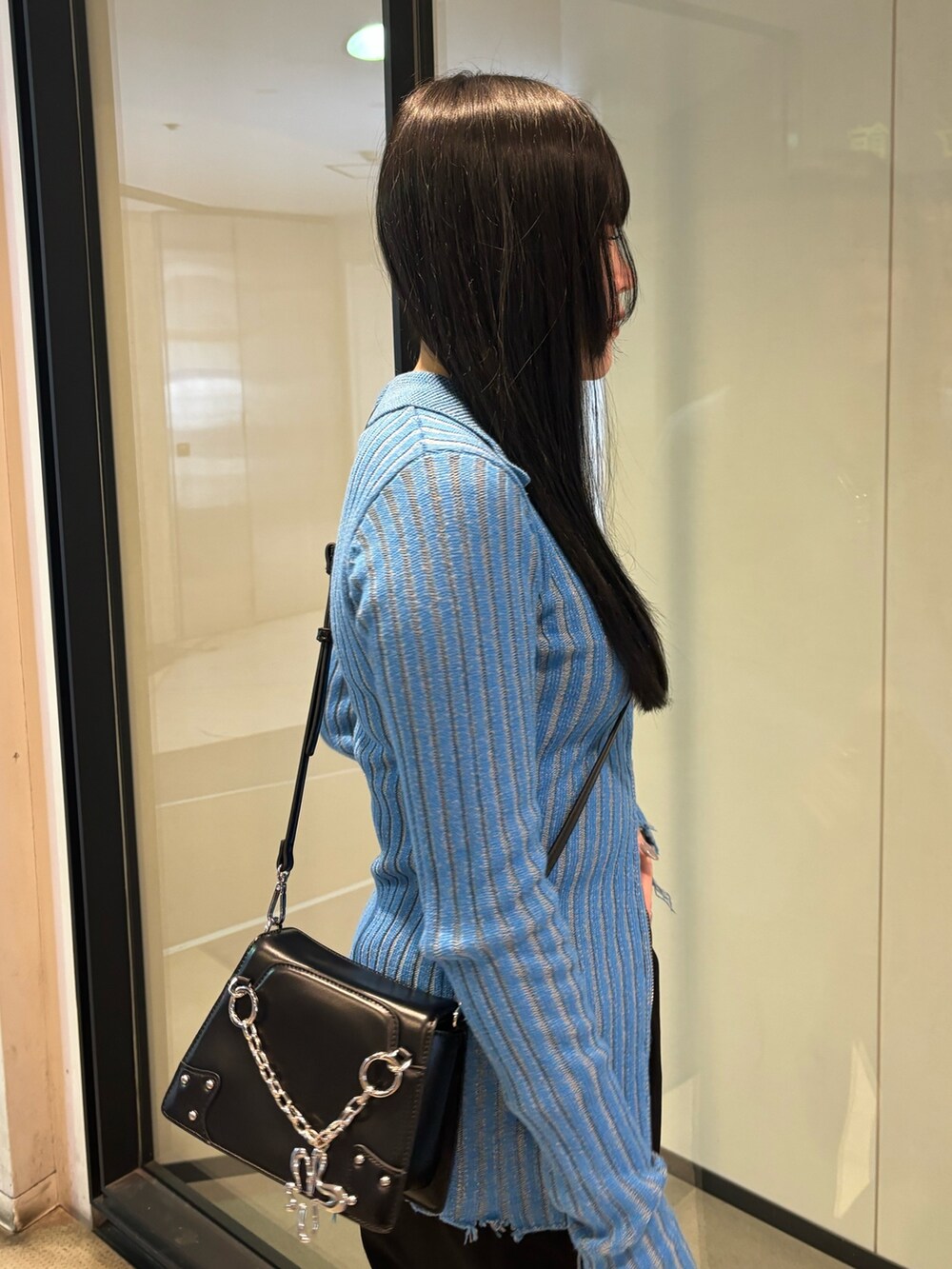 ブラック系のスニーカー、ブルー系のニット/セーター、ブラック系のその他パンツを着用したレディースの冬コーディネートの5枚目の写真