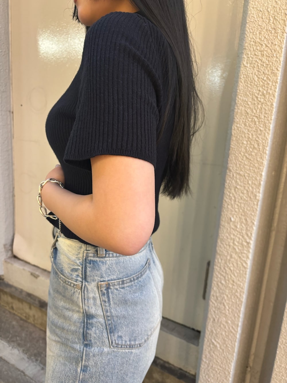 ホワイト系のデニムパンツ、ブラック系のニット/セーター、ブラック系のサンダルを着用したレディースの夏コーディネートの5枚目の写真