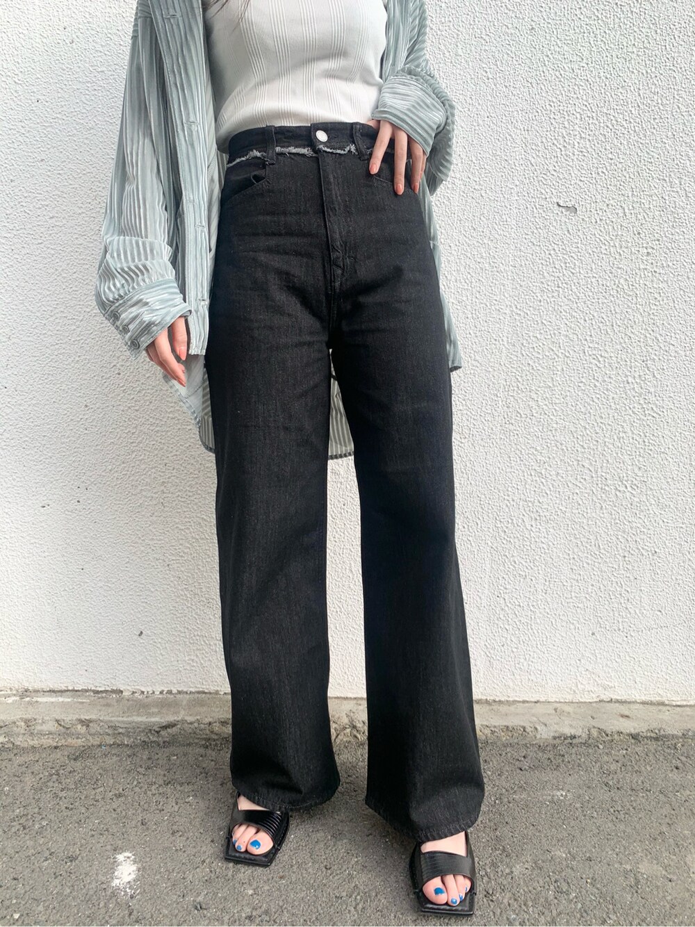 グリーン系のシャツ/ブラウス、ブラック系のサンダル、ブラック系のデニムパンツを着用したレディースの春コーディネートの5枚目の写真