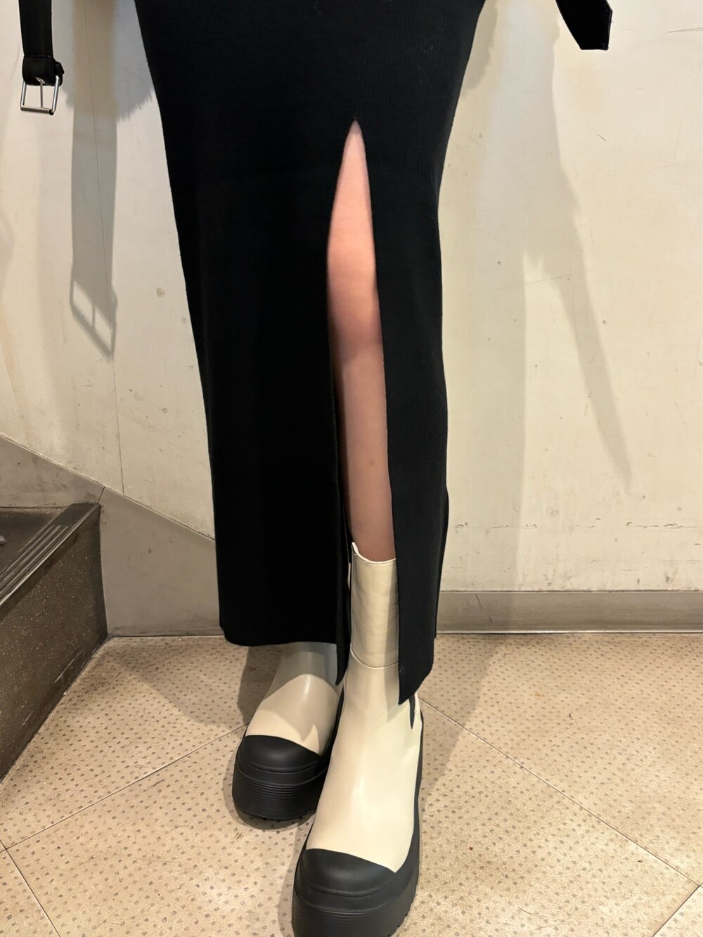 ブラック系のムートンコート、ブラック系のワンピース、ホワイト系のブーツを着用したレディースの秋コーディネートの8枚目の写真