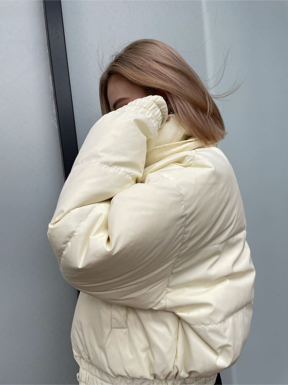 ブラック系のブーツ、ホワイト系のダウンジャケット/コート、ブラック系のデニムパンツを着用したレディースの冬コーディネートの3枚目の写真