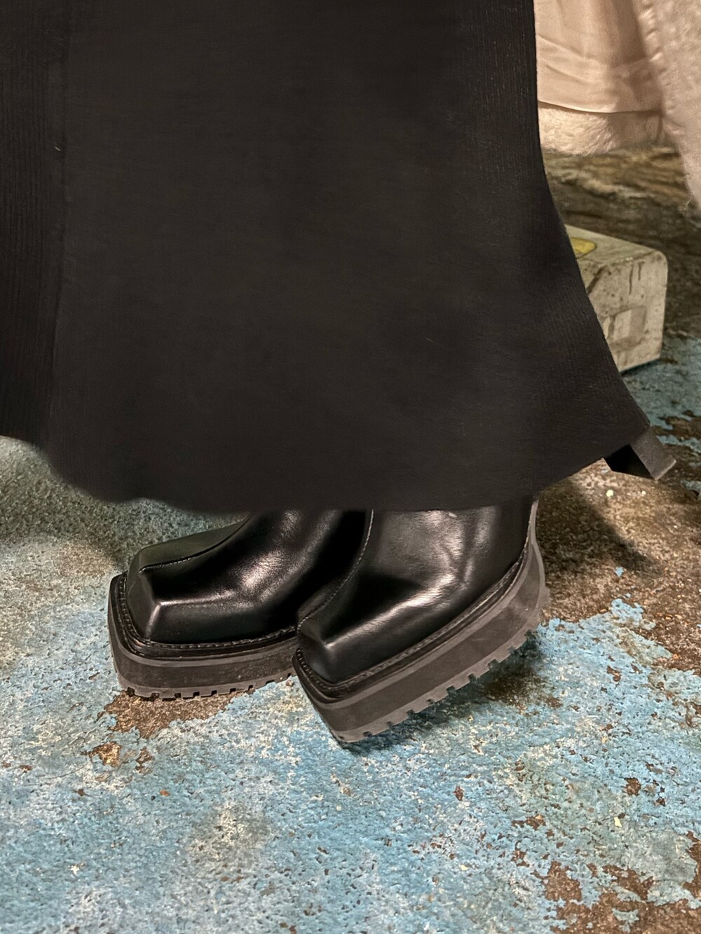 ホワイト系のチェスターコート、ブラック系のブーツ、ブラック系のハンドバッグを着用したレディースの冬コーディネートの9枚目の写真