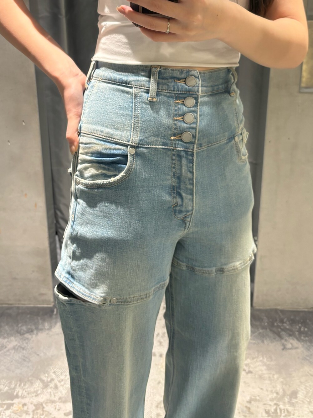 ブルー系のデニムパンツ、ブラック系のサンダル、ホワイト系のTシャツ/カットソーを着用したレディースの春コーディネートの5枚目の写真