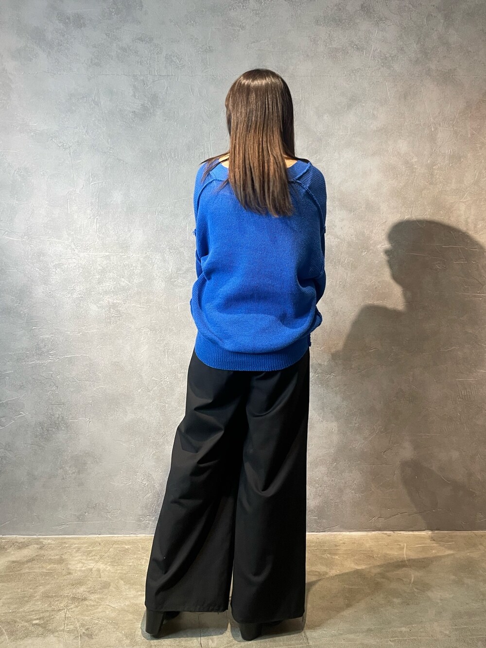 ブラック系のその他パンツ、ブラック系のブーツ、ブルー系のカーディガン/ボレロを着用したレディースの冬コーディネートの3枚目の写真