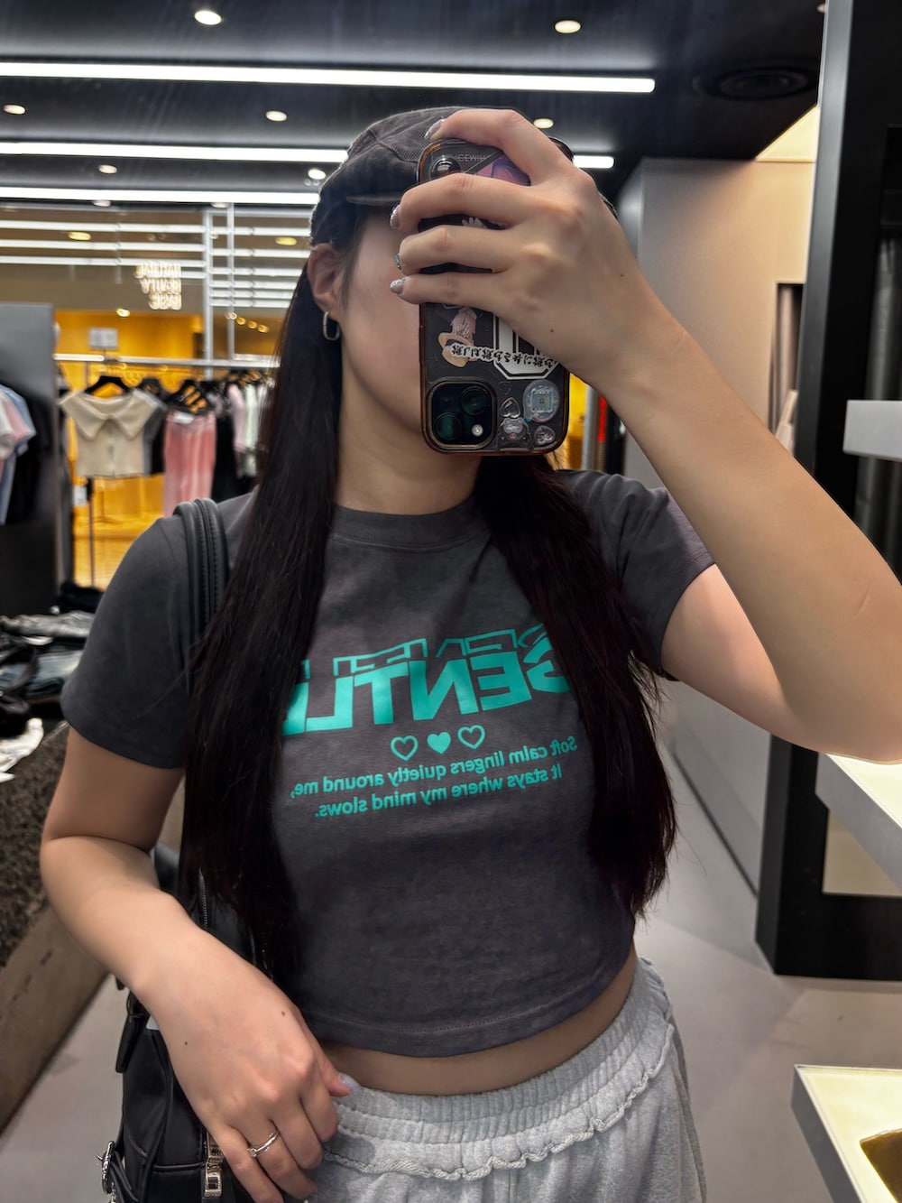 グレー系のTシャツ/カットソー、ホワイト系のハンドバッグ、グレー系のスウェットパンツを着用したレディースの春コーディネートの3枚目の写真