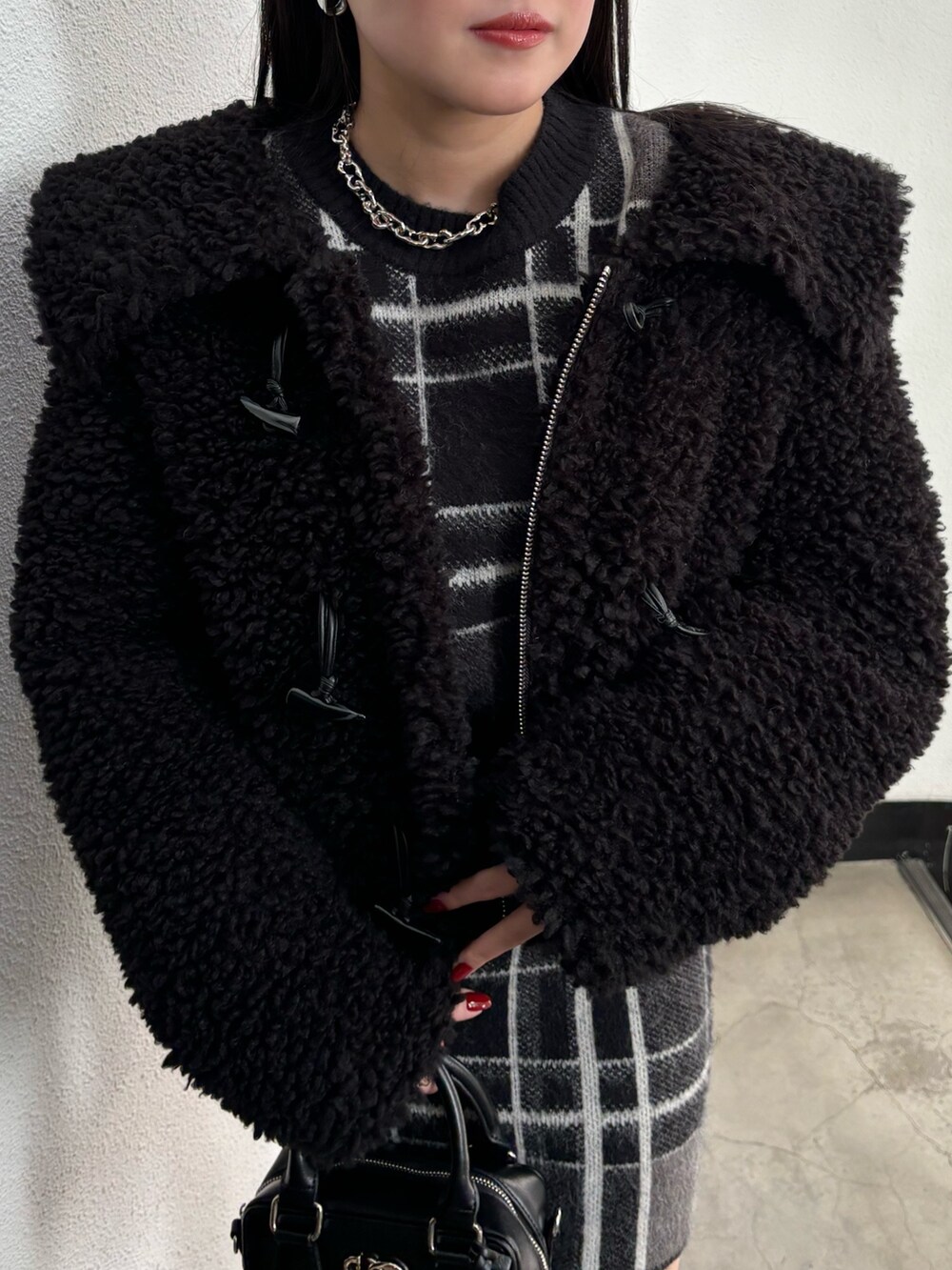 ブラック系のブルゾン、ブラック系のニット/セーター、ブラック系のスカートを着用したレディースの冬コーディネートの4枚目の写真