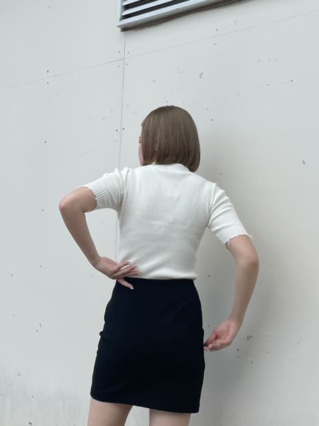 ブラック系のスカート、ブラック系のサンダル、ホワイト系のニット/セーターを着用したレディースの秋コーディネートの5枚目の写真