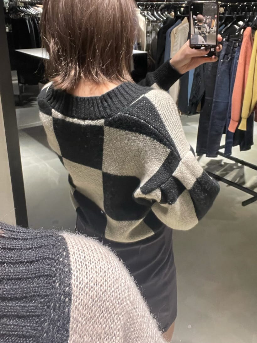 グレー系のスカート、ブラック系のブーツ、ブラック系のカーディガン/ボレロを着用したレディースの冬コーディネートの4枚目の写真