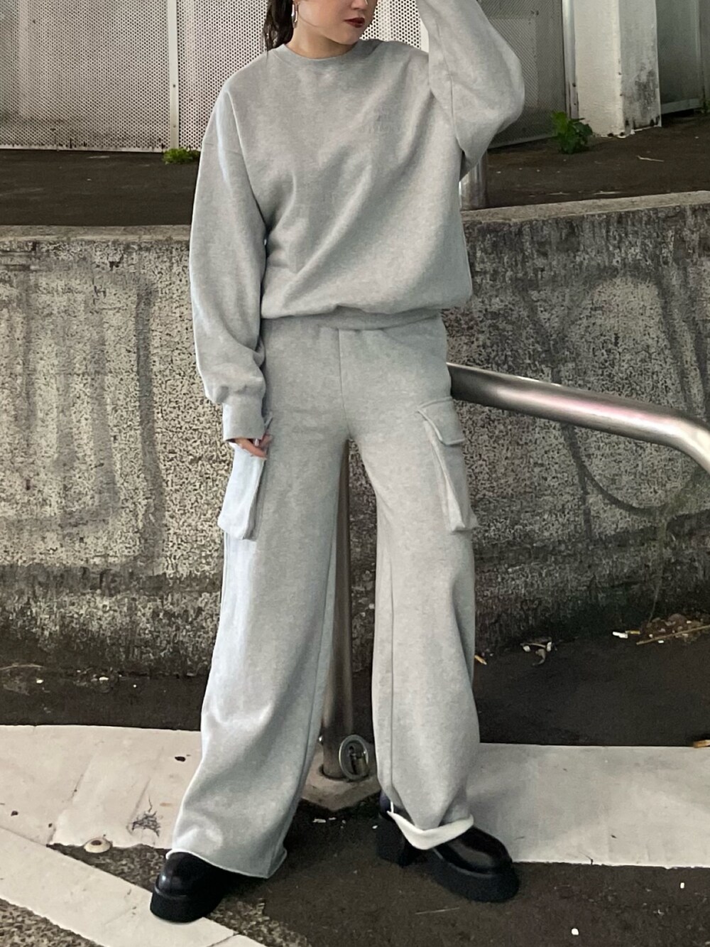 グレー系のTシャツ/カットソー、グレー系のスウェットパンツ、ブラック系のブーツを着用したレディースの秋コーディネートの2枚目の写真