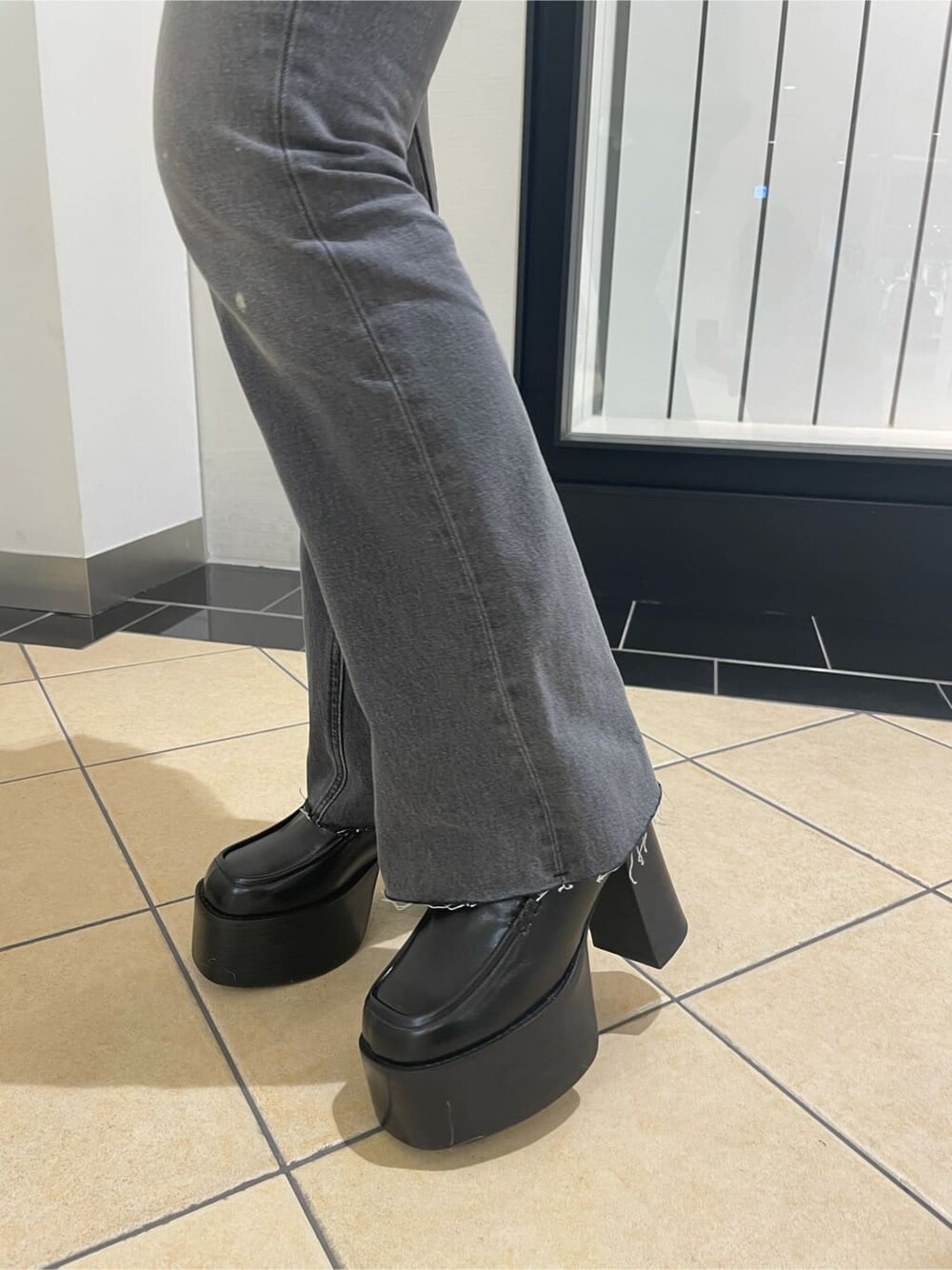 ブラック系のローファー、グレー系のデニムパンツ、ベージュ系のニット/セーターを着用したレディースの冬コーディネートの5枚目の写真