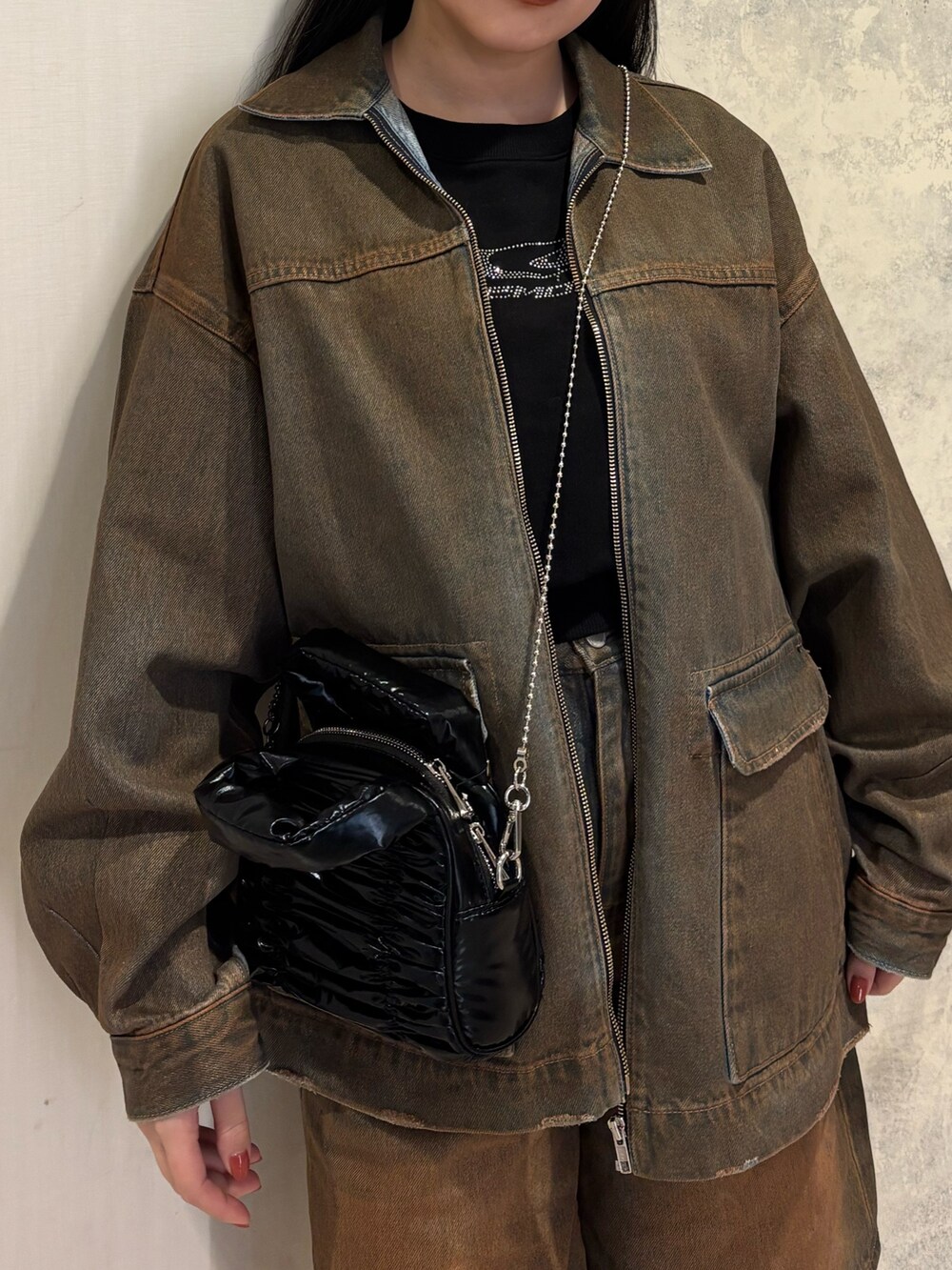 ブラック系のデニムパンツ、ブラック系のブーツ、ブラック系のブルゾンを着用したレディースの冬コーディネートの4枚目の写真