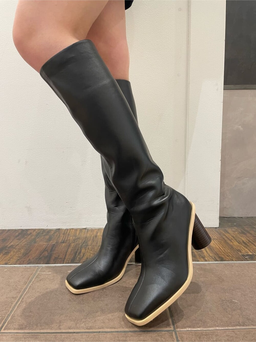 ブラック系のワンピース、ブラウン系のテーラードジャケット、ブラック系のブーツを着用したレディースの春コーディネートの7枚目の写真