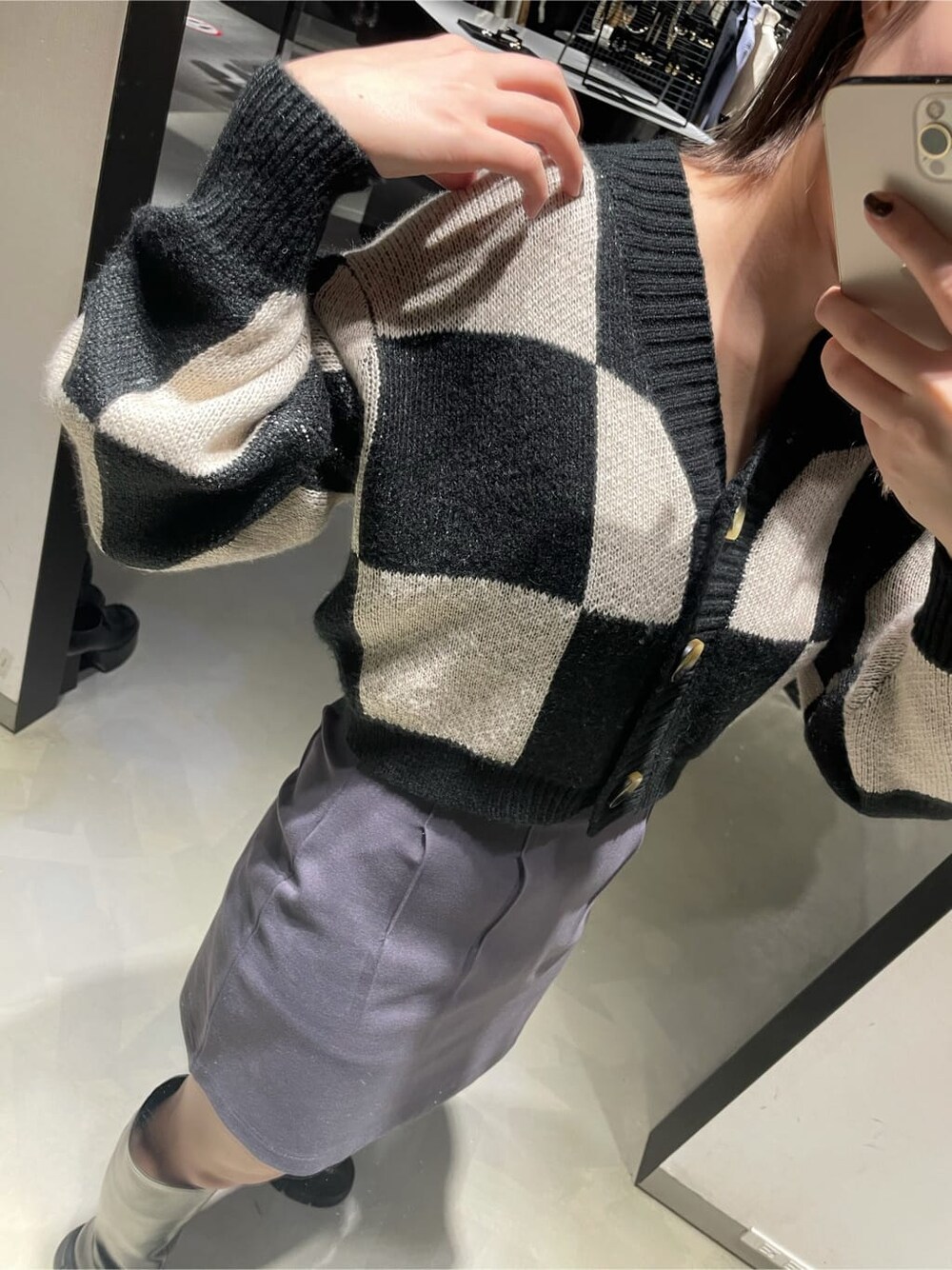 グレー系のスカート、ブラック系のブーツ、ブラック系のカーディガン/ボレロを着用したレディースの冬コーディネートの3枚目の写真