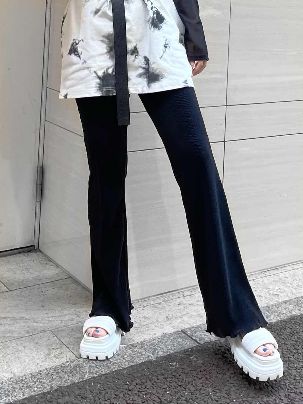 ブラック系のその他パンツ、ブラック系のTシャツ/カットソー、ホワイト系のサンダルを着用したレディースの春コーディネートの4枚目の写真