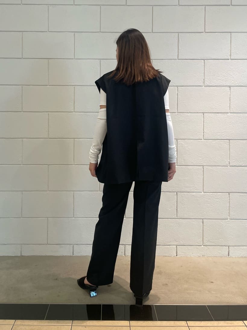 ブラック系のベスト、ブラック系のその他パンツ、ブラック系のサンダルを着用したレディースの夏コーディネートの3枚目の写真