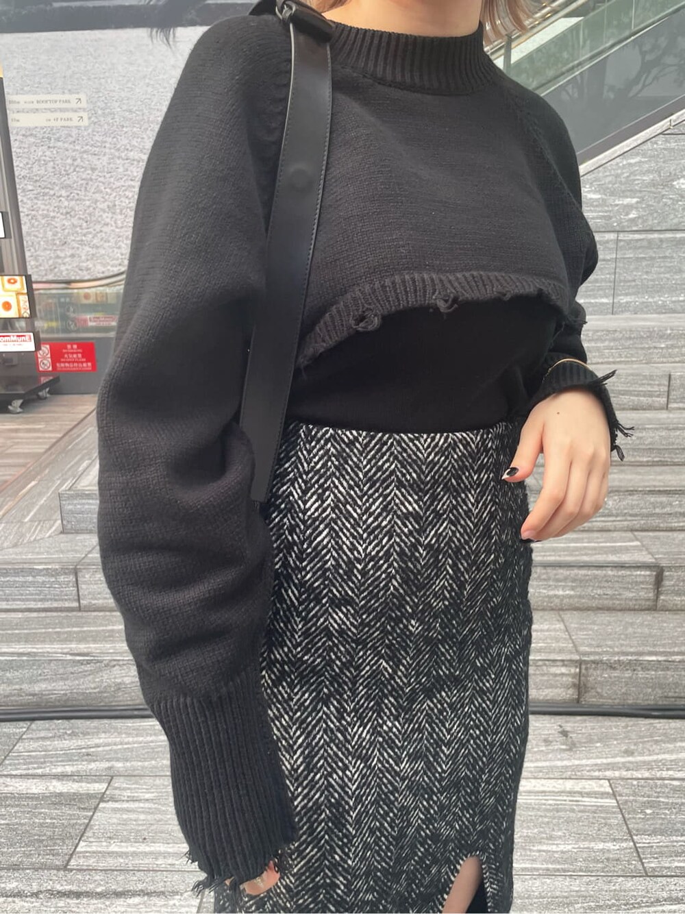 ブラック系のスカート、ブラック系のニット/セーター、ブラック系のキャミソールを着用したレディースの秋コーディネートの4枚目の写真