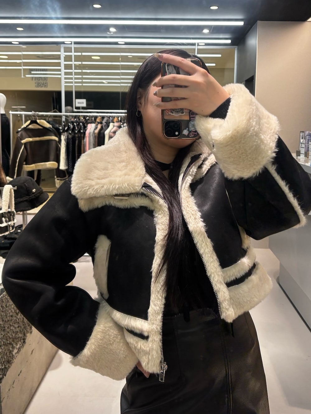 ブラック系のブルゾン、ブラック系のニット/セーター、ホワイト系のブーツを着用したレディースの冬コーディネートの3枚目の写真