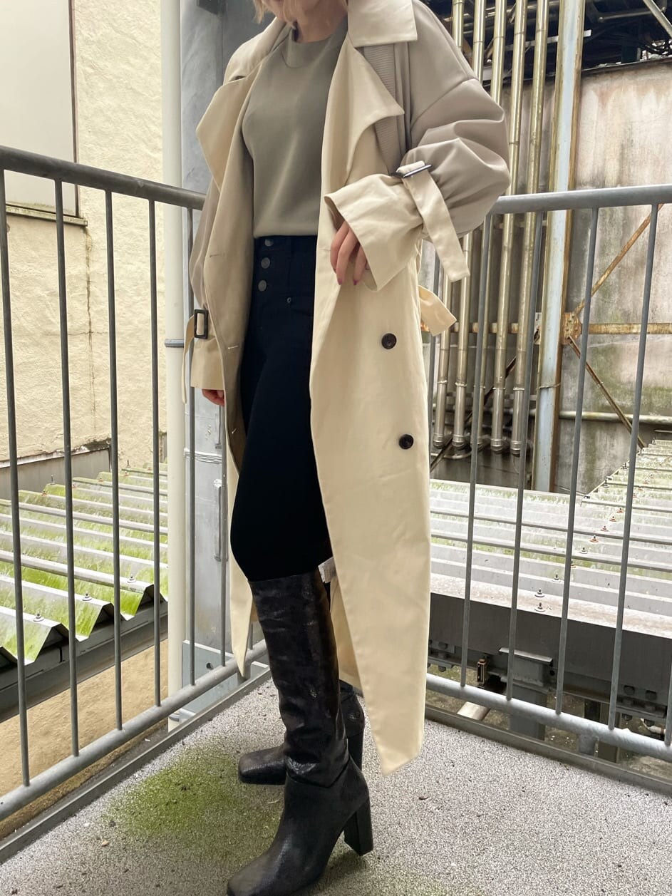 ブラック系のデニムパンツ、ホワイト系のトレンチコート、その他のブーツを着用したレディースの秋コーディネートの6枚目の写真