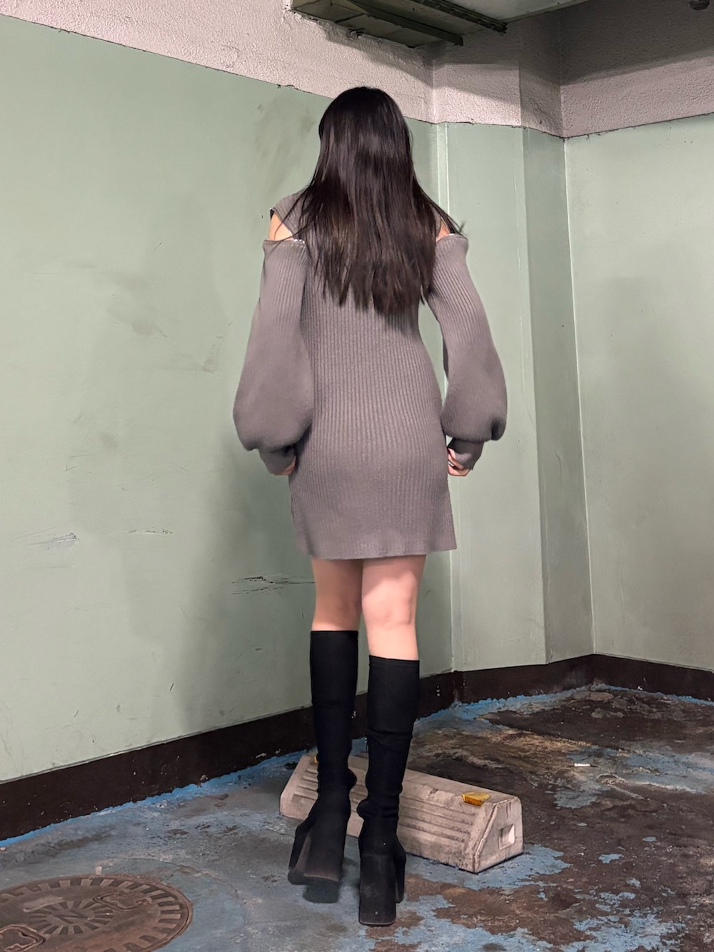 ブラック系のブルゾン、グレー系のワンピース、その他のブーツを着用したレディースの冬コーディネートの6枚目の写真