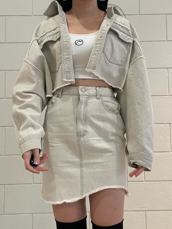 ホワイト系のデニムジャケット、ホワイト系のタンクトップ、ブラック系のブーツを着用したレディースの夏コーディネートの4枚目の写真