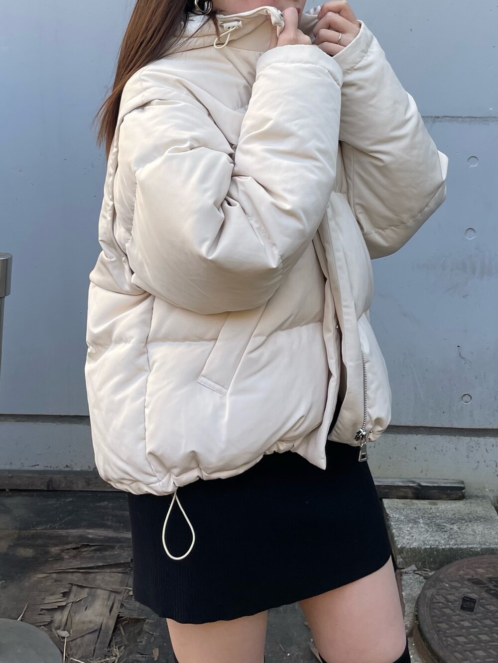 ホワイト系のダウンジャケット/コート、ブラック系のワンピース、ブラック系のブーツを着用したレディースの冬コーディネートの3枚目の写真