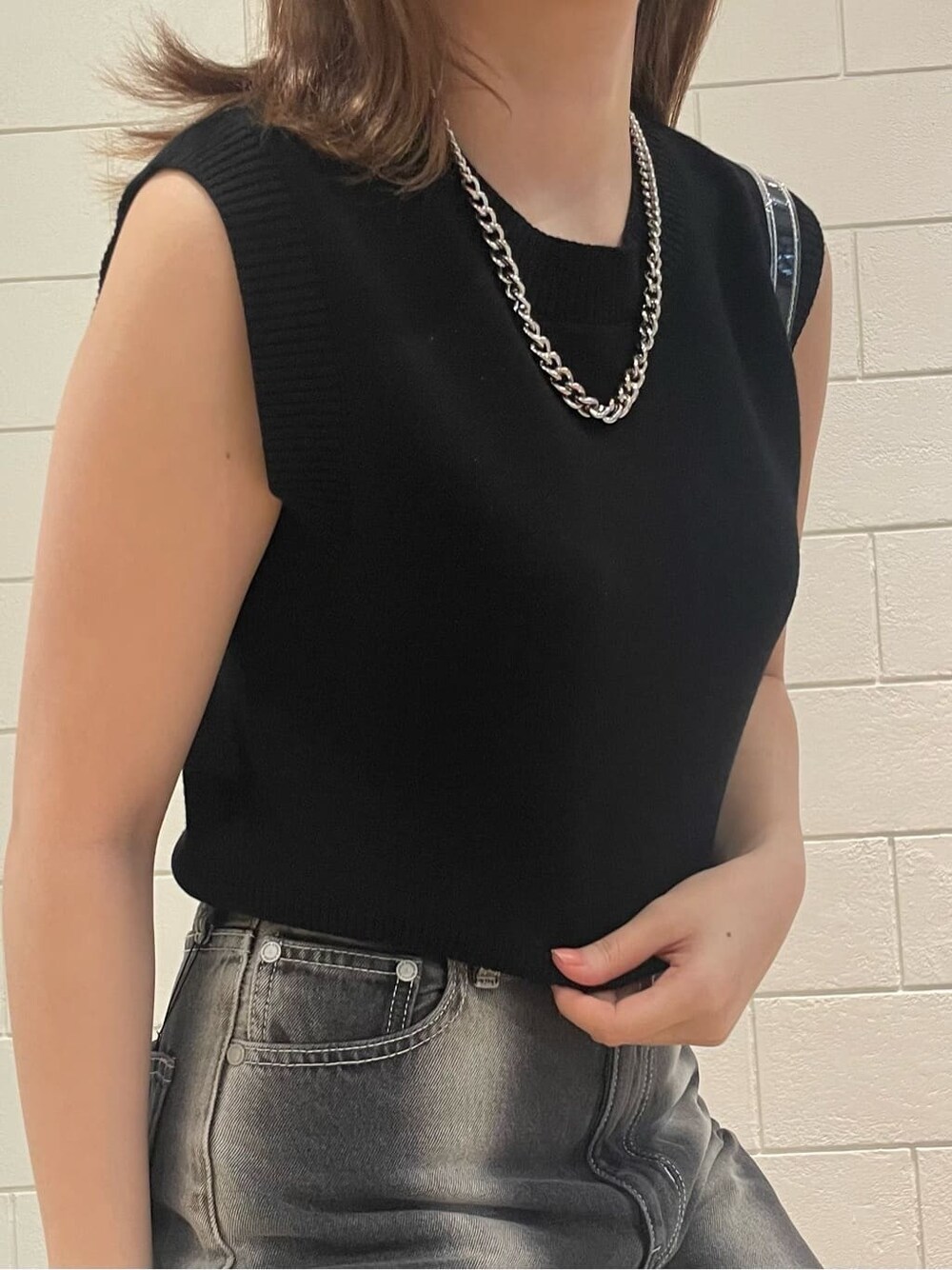 ブラック系のサンダル、ブラック系のタンクトップ、ブラック系のデニムパンツを着用したレディースの春コーディネートの3枚目の写真