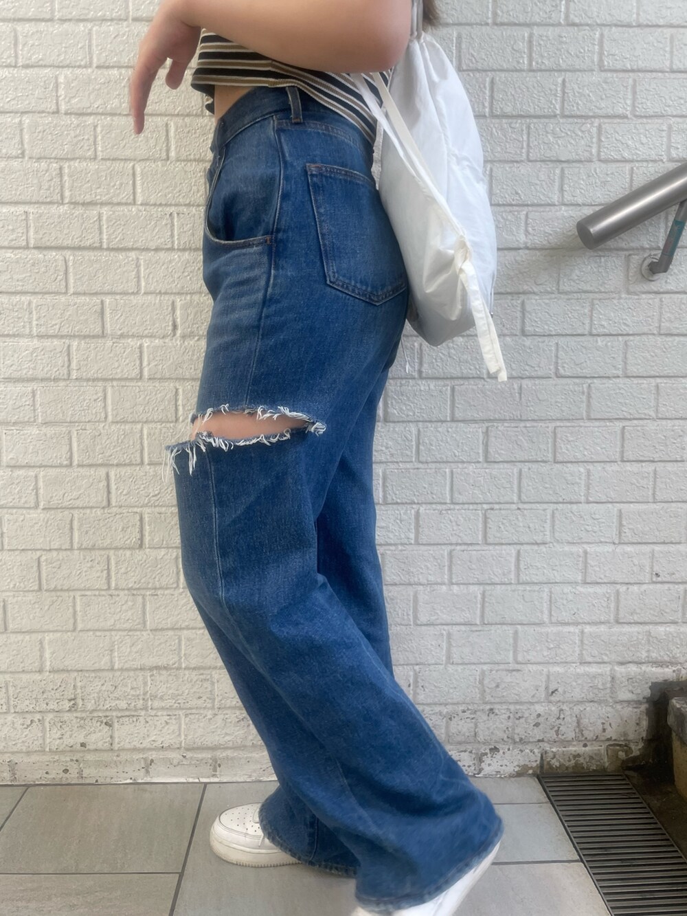 ブラック系のデニムパンツ、その他のTシャツ/カットソー、ホワイト系のバックパック/リュックを着用したレディースの夏コーディネートの7枚目の写真