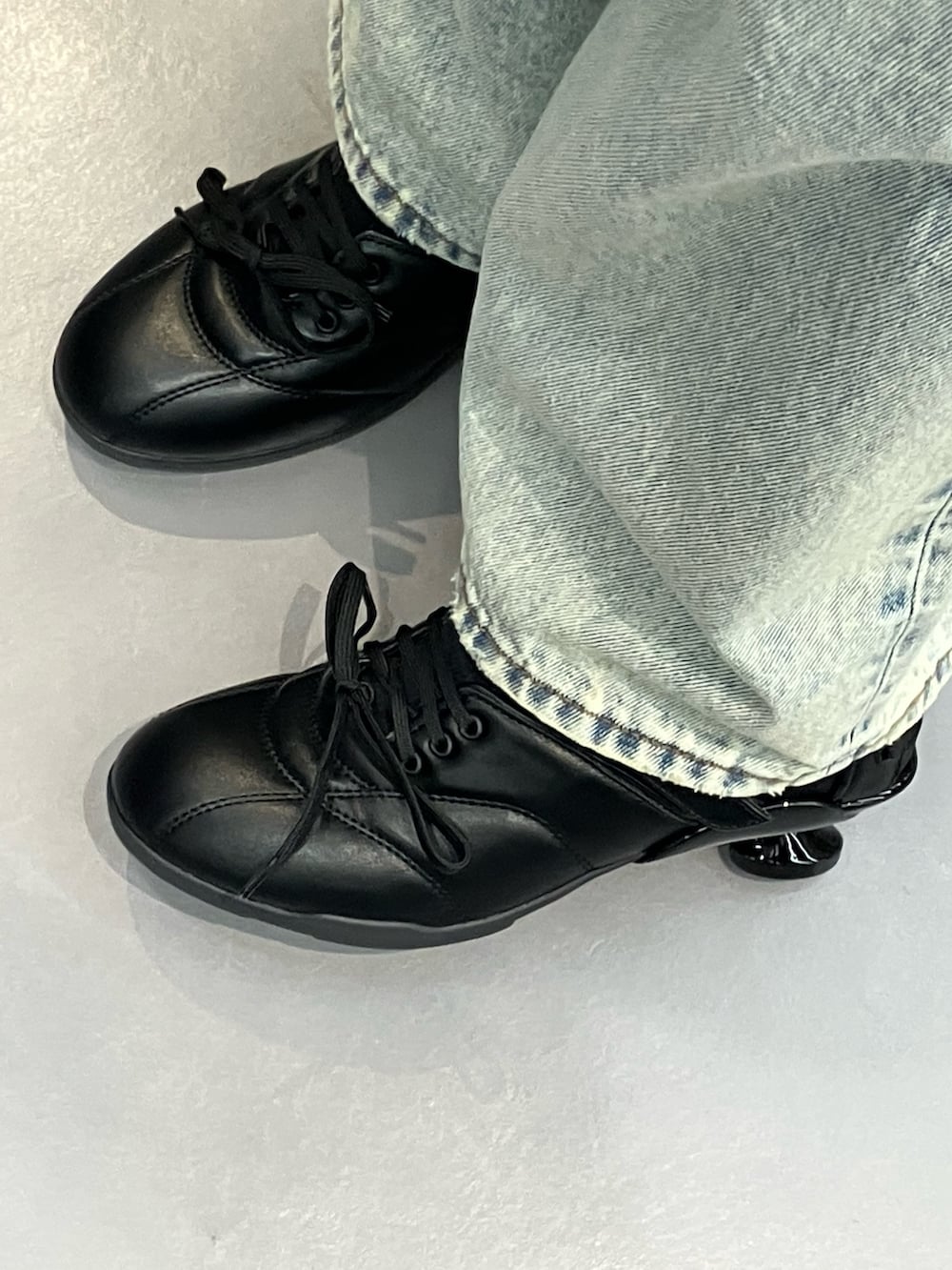 ブルー系のデニムパンツ、グレー系のTシャツ/カットソー、ブラック系のスニーカーを着用したレディースの春コーディネートの5枚目の写真