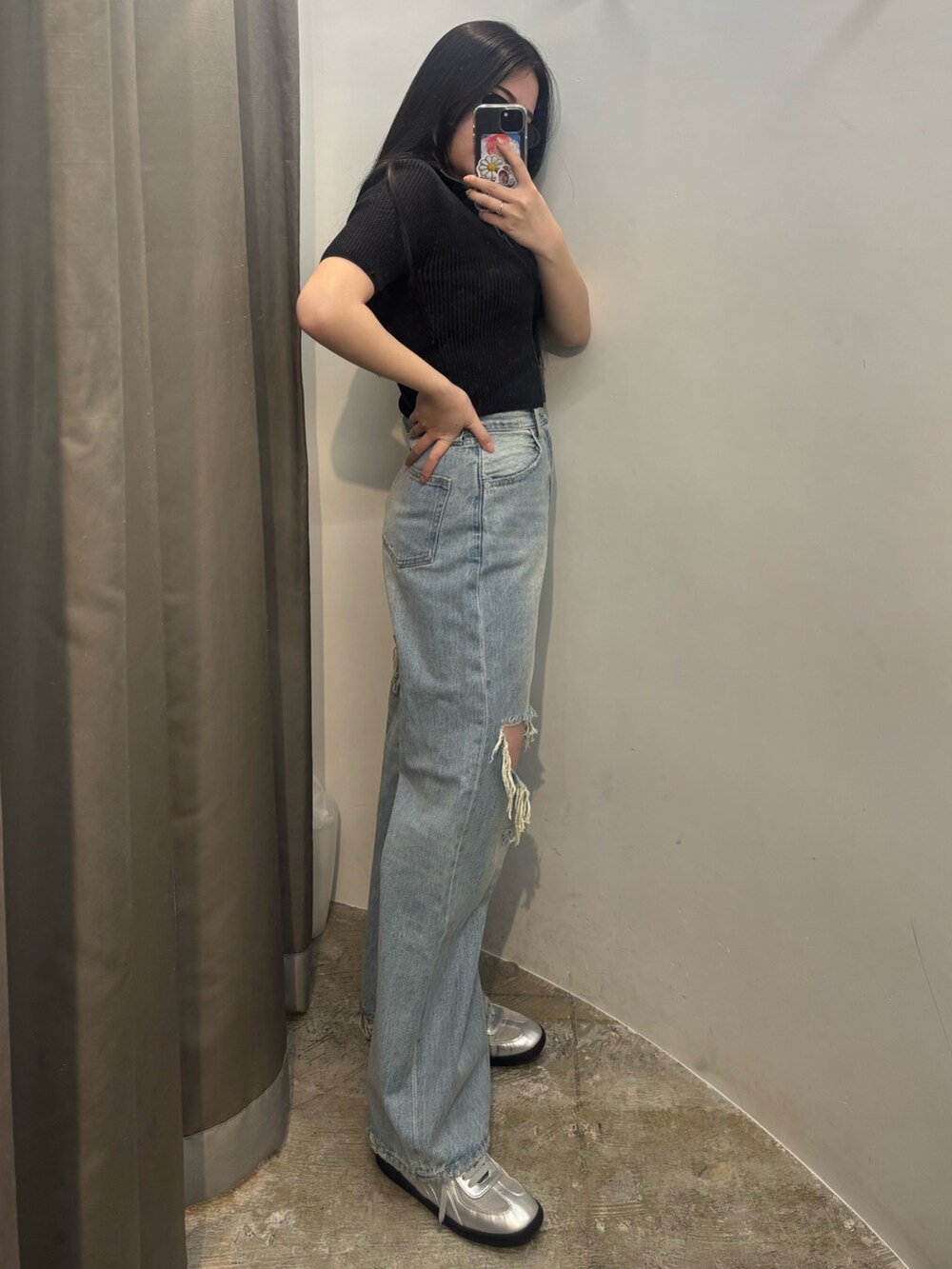 シルバー系のスニーカー、ブルー系のデニムパンツ、ブラック系のニット/セーターを着用したレディースの春コーディネートの2枚目の写真