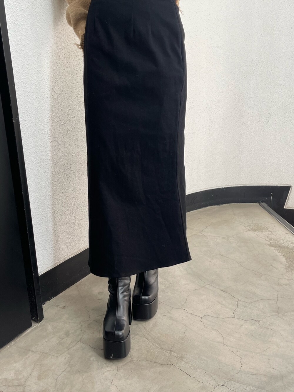 ブラック系のスカート、ブラック系のブーツ、その他のニット/セーターを着用したレディースの秋コーディネートの7枚目の写真