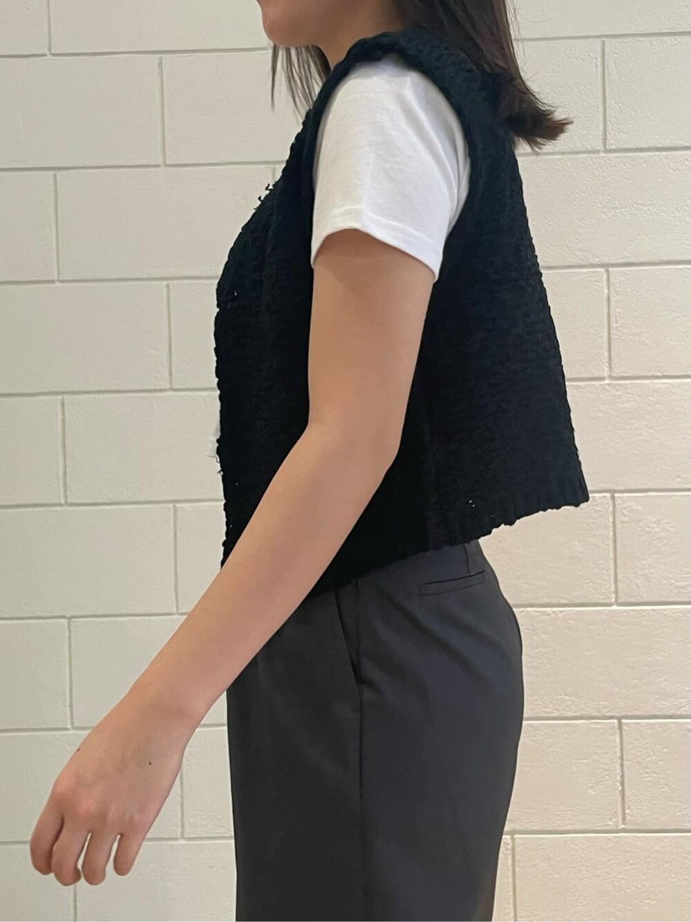 ブラック系のサンダル、ホワイト系のTシャツ/カットソー、ブラック系のベストを着用したレディースの夏コーディネートの4枚目の写真