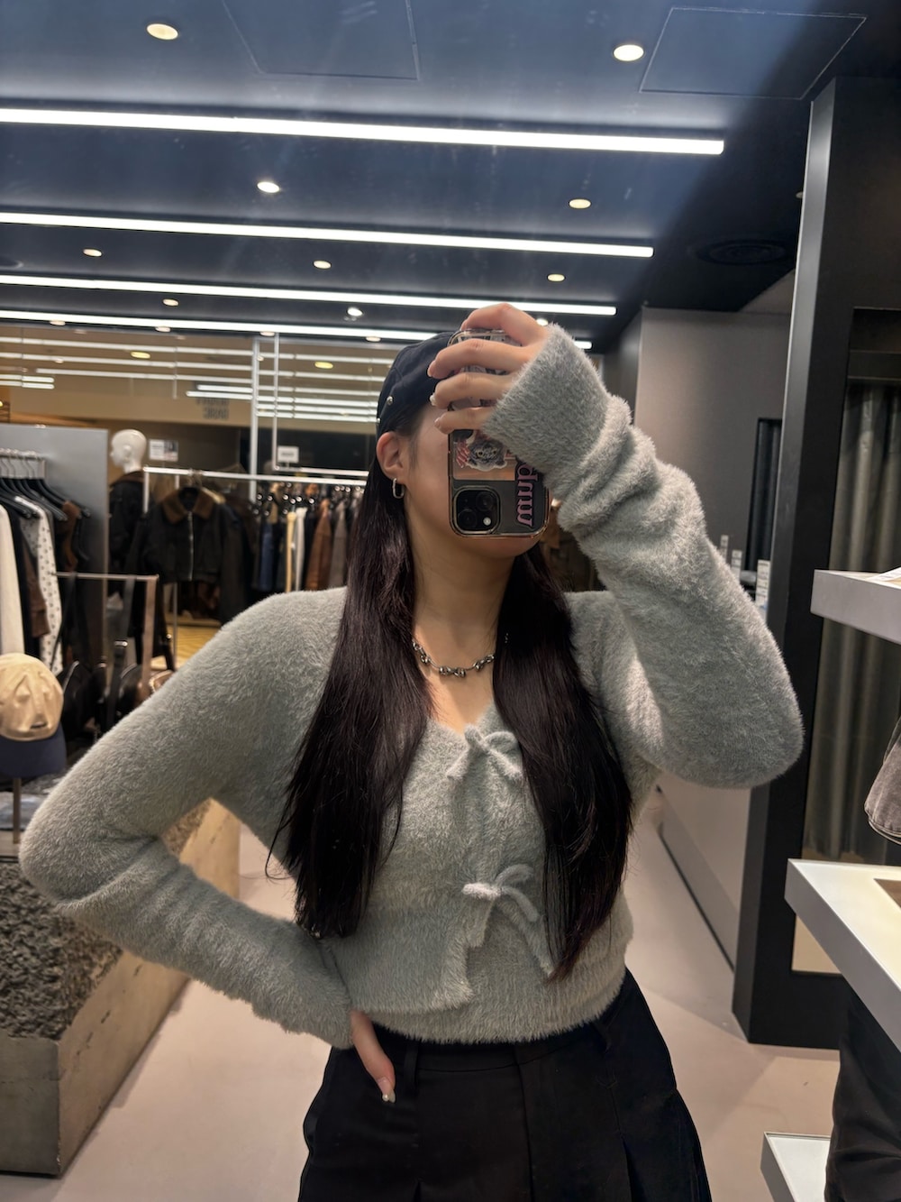 ホワイト系のブーツ、ブラック系のスカート、グレー系のニット/セーターを着用したレディースの秋コーディネートの3枚目の写真