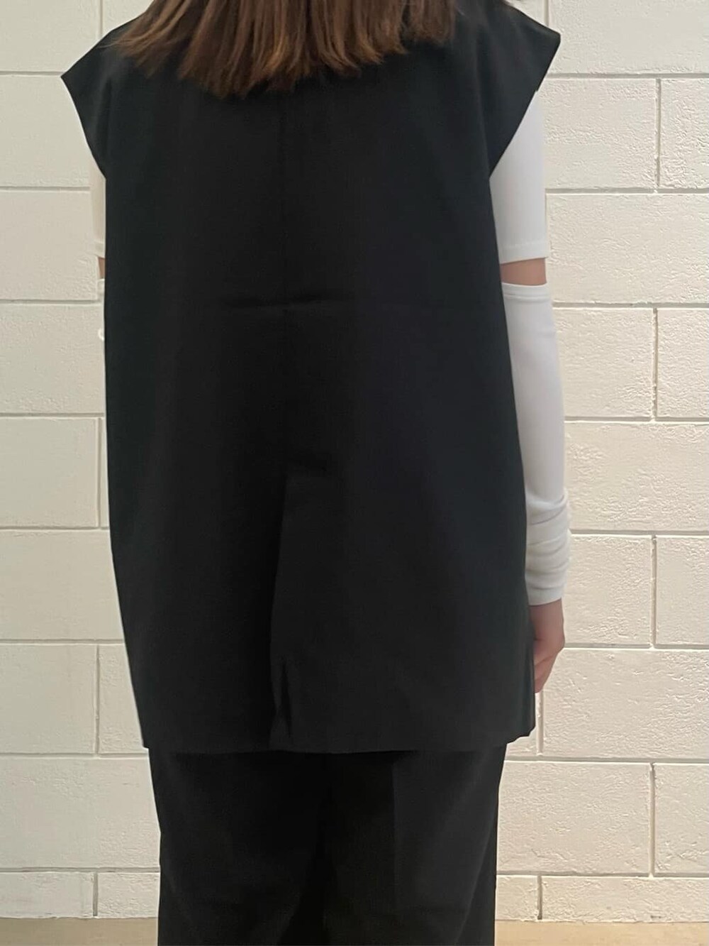 ブラック系のベスト、ブラック系のその他パンツ、ブラック系のサンダルを着用したレディースの夏コーディネートの7枚目の写真