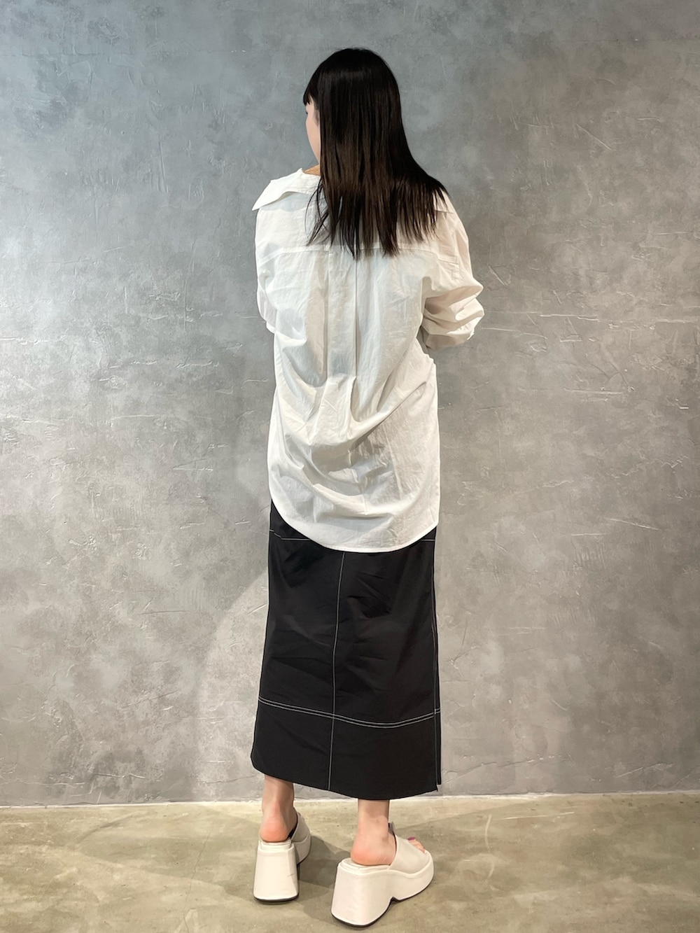 ホワイト系のサンダル、ホワイト系のキャミソール、ブラック系のスカートを着用したレディースの春コーディネートの3枚目の写真