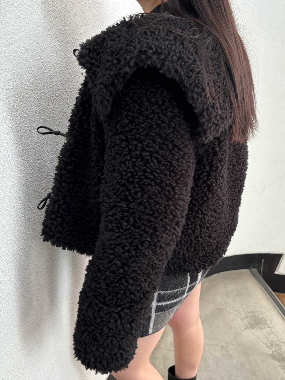 ブラック系のブルゾン、ブラック系のニット/セーター、ブラック系のスカートを着用したレディースの冬コーディネートの7枚目の写真