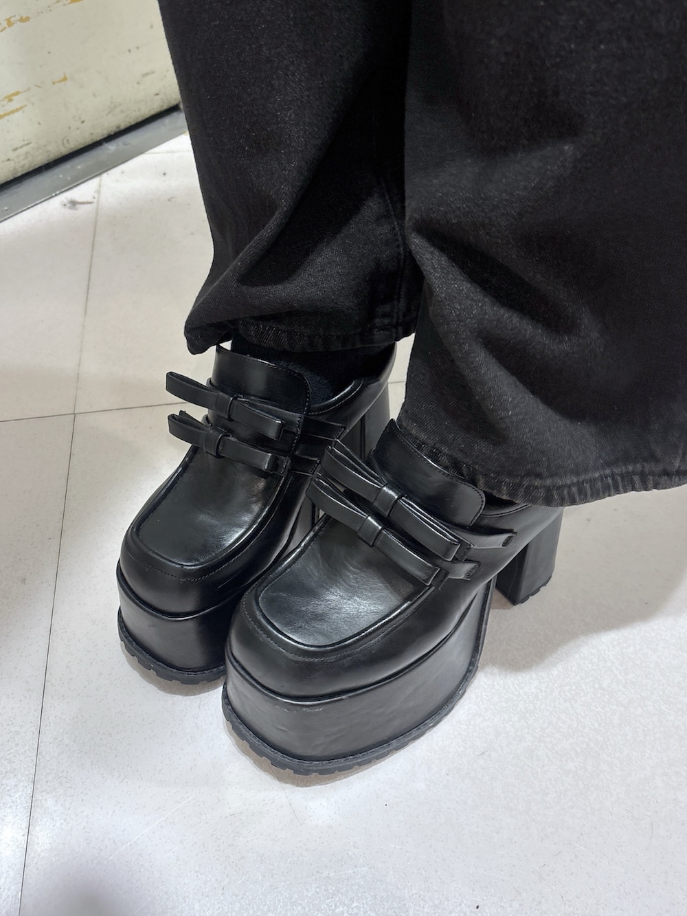 ブラック系のローファー、ブラック系のデニムパンツ、ブラック系のTシャツ/カットソーを着用したレディースの秋コーディネートの5枚目の写真
