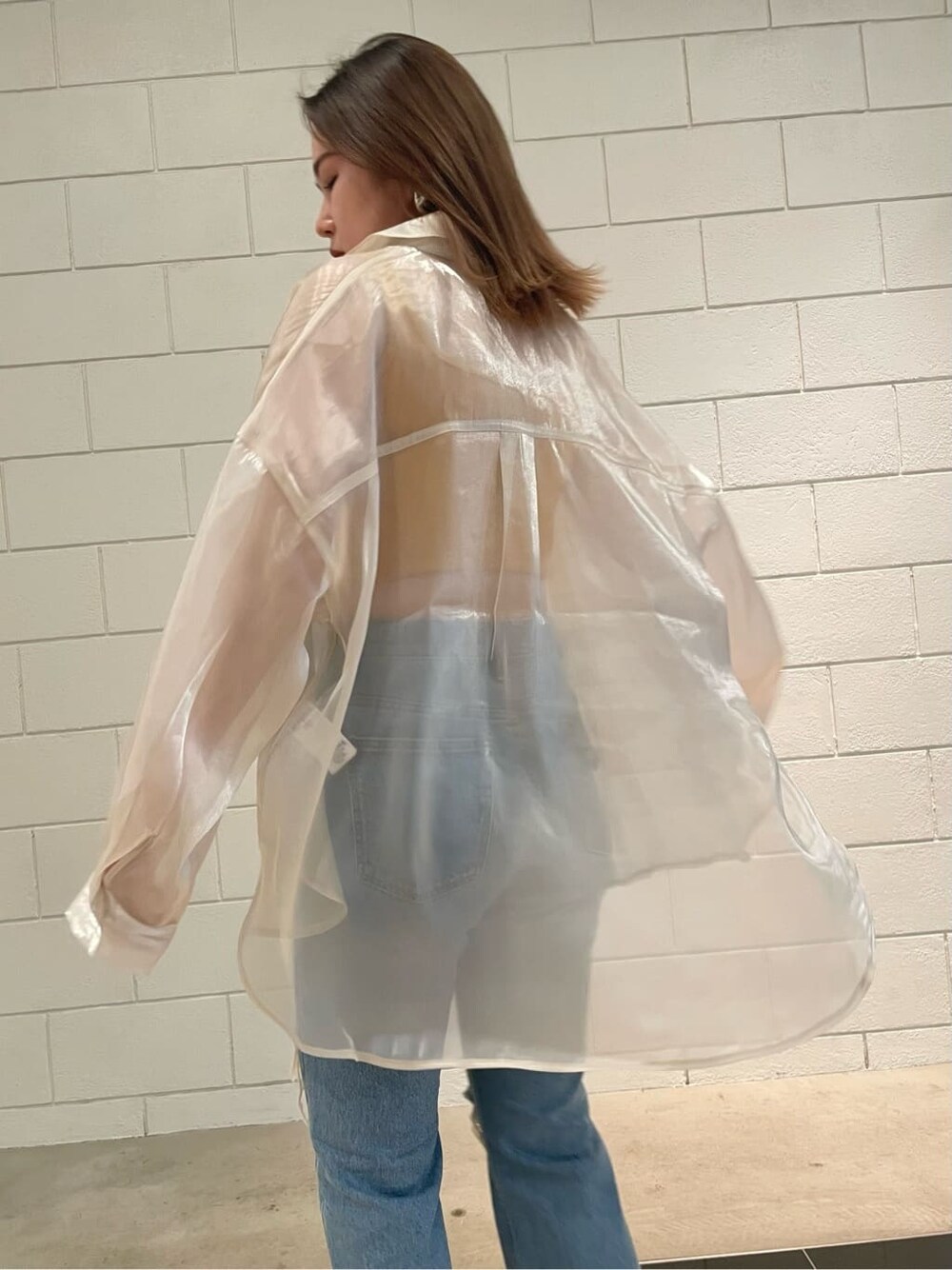 ブラック系のサンダル、ホワイト系のシャツ/ブラウス、ブルー系のデニムパンツを着用したレディースの春コーディネートの5枚目の写真