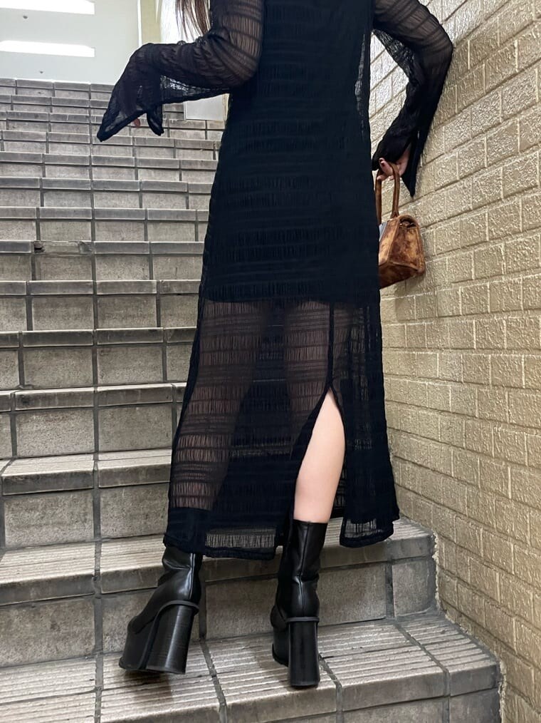 ブラック系のブーツ、ブラック系のワンピース、シルバー系のネックレスを着用したレディースの秋コーディネートの4枚目の写真