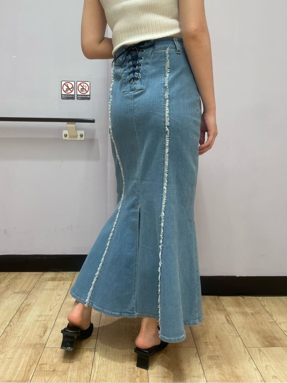 ホワイト系のタンクトップ、ブルー系のスカート、ブラック系のサンダルを着用したレディースの夏コーディネートの7枚目の写真